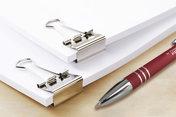Kugelschreiber mit Gravur neben Firmendokumenten